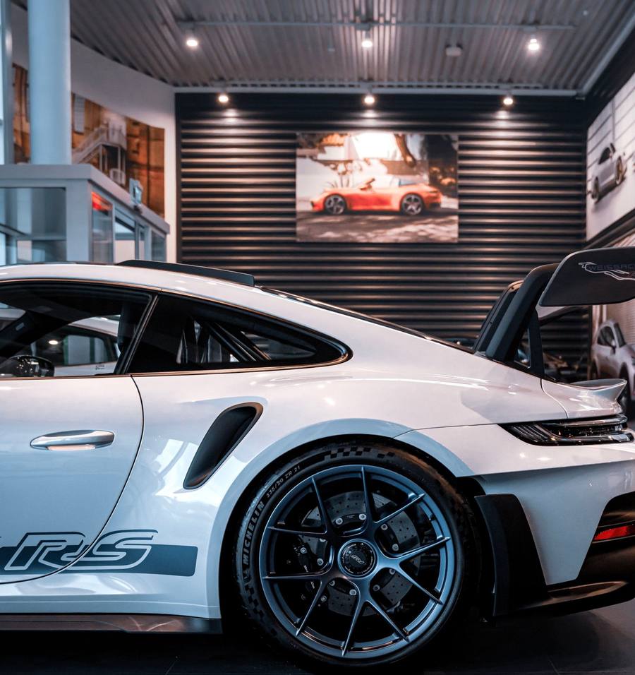 Rear of a white Porsche 911 in a showroom